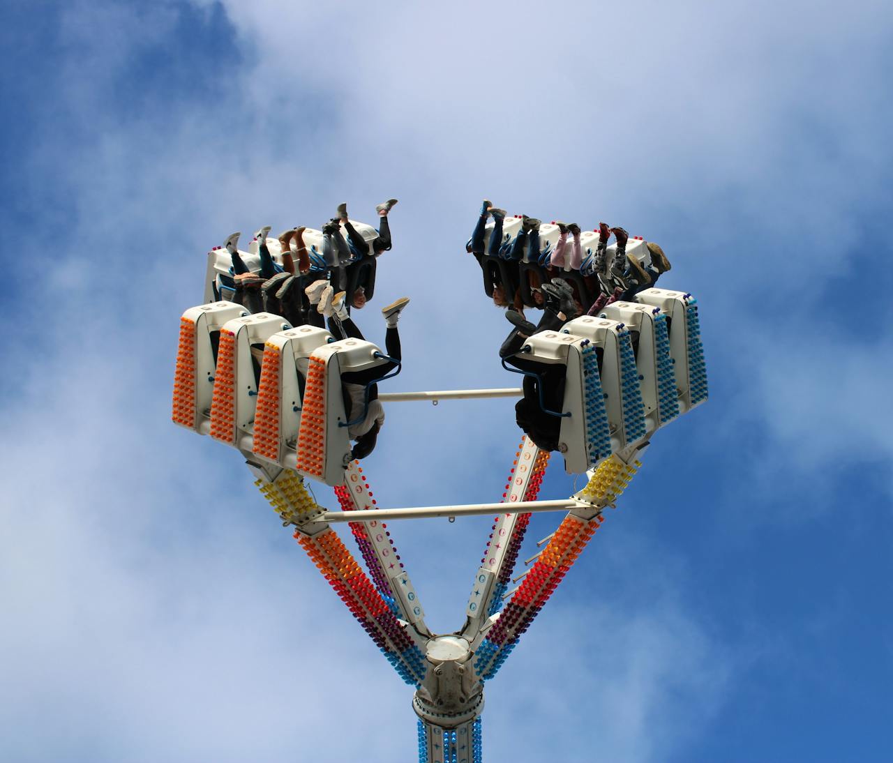 People enjoying a thrilling ride at an amusement park against a bright blue sky in Circleville, Ohio.